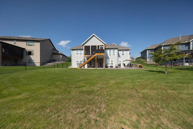 rear view of property featuring a patio, a sunroom, and a yard