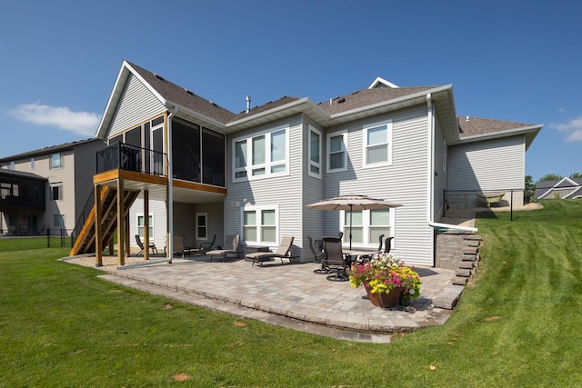 back of house with a sunroom, a fire pit, a patio area, and a lawn