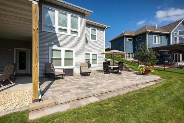 rear view of property featuring a yard, a pergola, and a patio