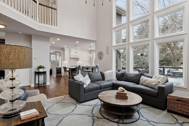 living room featuring a high ceiling, wine cooler, and wood finished floors