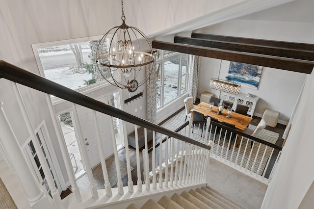 stairs with a notable chandelier and a wealth of natural light