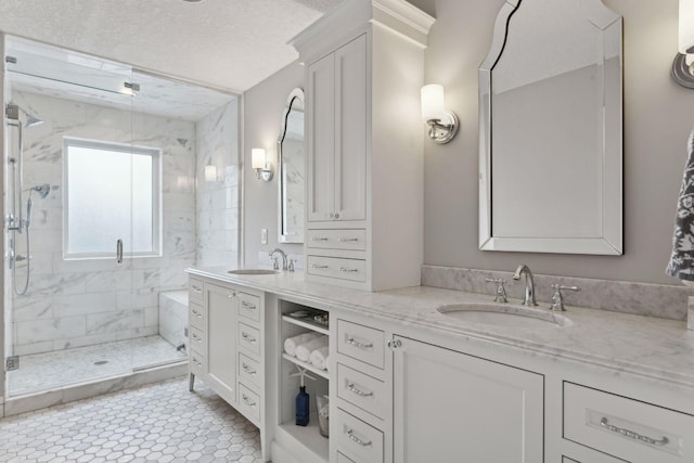 full bathroom with vanity, a textured ceiling, and a shower stall