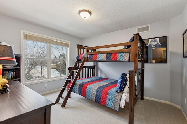 carpeted bedroom featuring a textured ceiling, baseboards, and visible vents