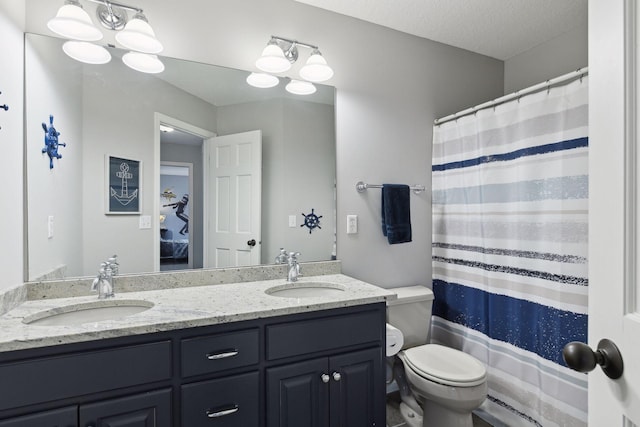 ensuite bathroom featuring a sink, ensuite bathroom, toilet, and double vanity