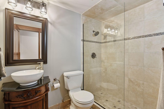 full bath featuring vanity, baseboards, toilet, and tiled shower