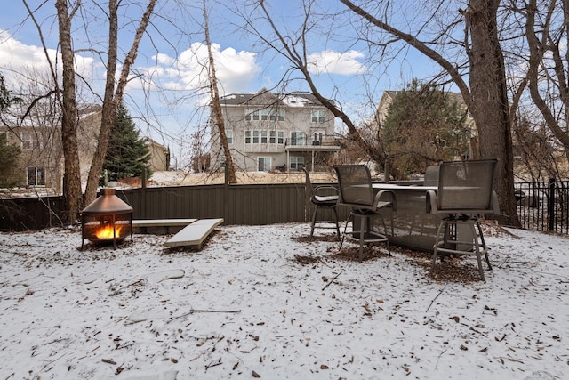 snowy yard featuring fence
