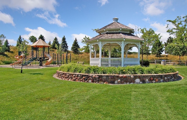 view of home's community featuring a lawn, a gazebo, fence, and playground community