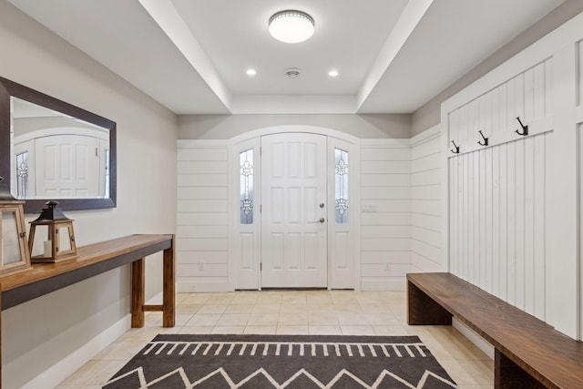 interior space featuring a raised ceiling and light tile patterned floors