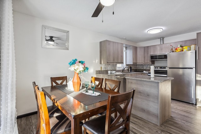 dining room with sink, dark wood-type flooring, and ceiling fan