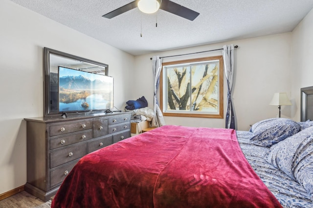 bedroom with wood-type flooring, ceiling fan, and a textured ceiling