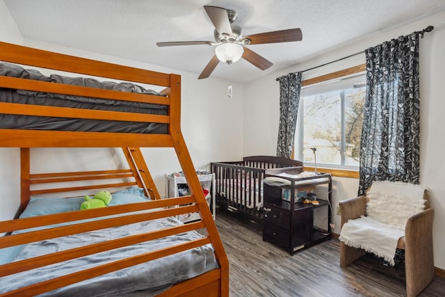 bedroom with wood-type flooring, ceiling fan, and a textured ceiling