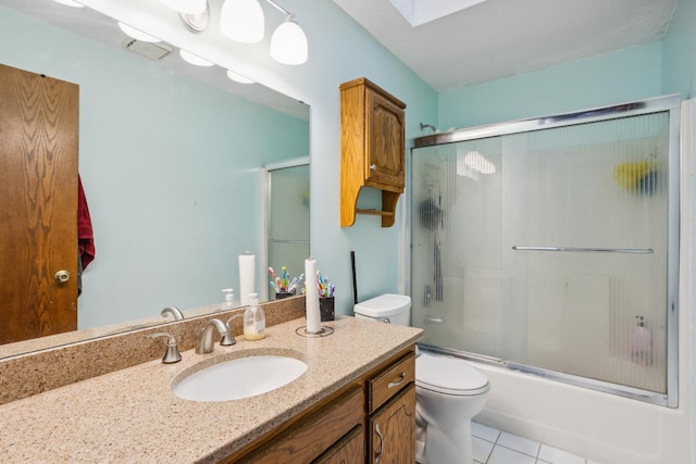 full bathroom with toilet, shower / bath combination with glass door, a skylight, vanity, and tile patterned flooring