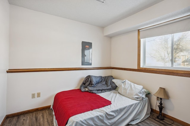 bedroom featuring dark wood-type flooring and electric panel