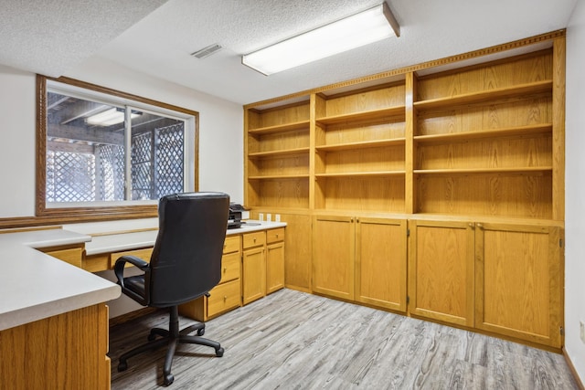 office area featuring light hardwood / wood-style flooring and a textured ceiling