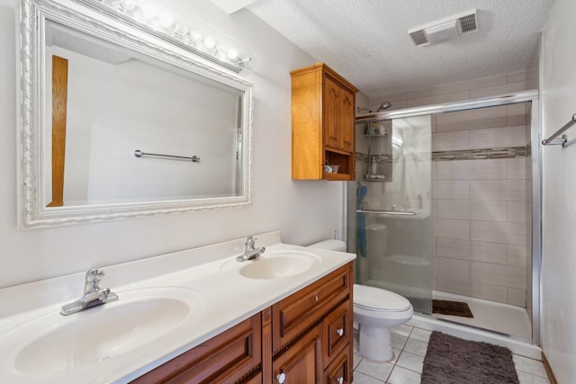 bathroom with a shower with door, tile patterned flooring, a textured ceiling, and toilet