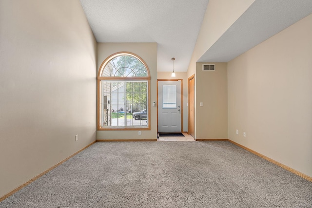 carpeted empty room featuring a textured ceiling