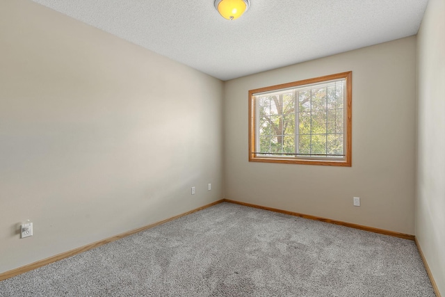 carpeted empty room with a textured ceiling