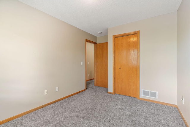 empty room with carpet and a textured ceiling