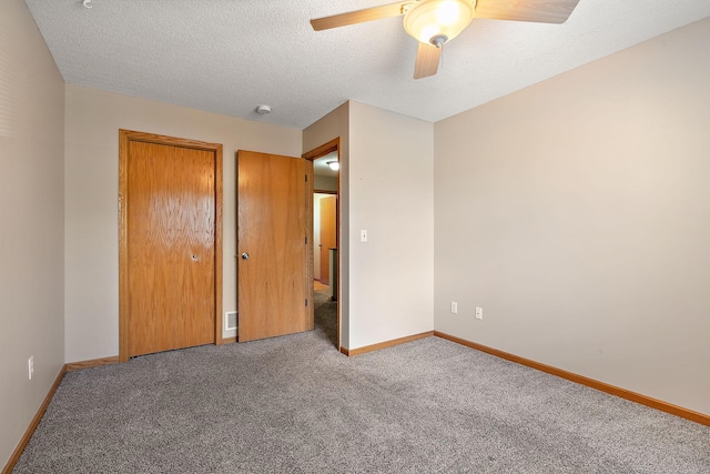 unfurnished bedroom featuring ceiling fan, carpet flooring, and a textured ceiling