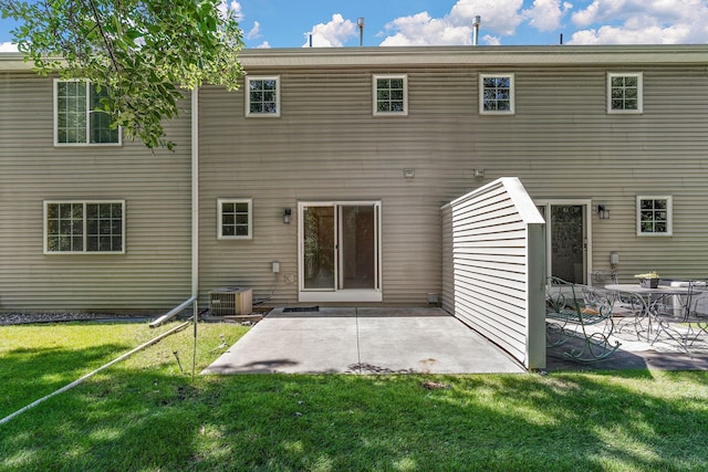 rear view of house featuring a patio, central AC, and a lawn