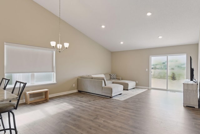 living room featuring hardwood / wood-style flooring, a chandelier, and high vaulted ceiling