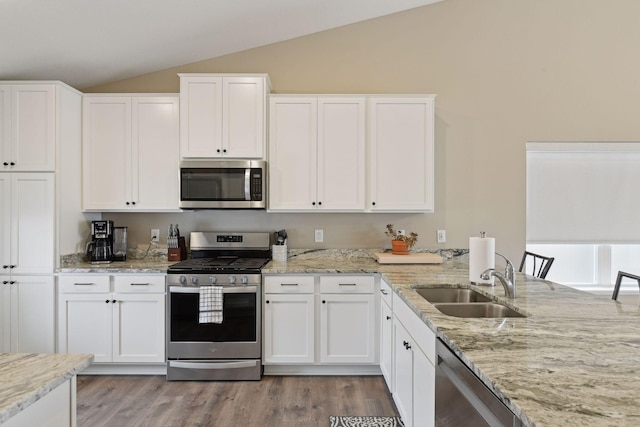 kitchen with sink, white cabinetry, vaulted ceiling, stainless steel appliances, and hardwood / wood-style floors