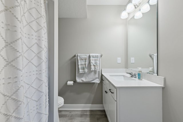 bathroom featuring walk in shower, vanity, and toilet