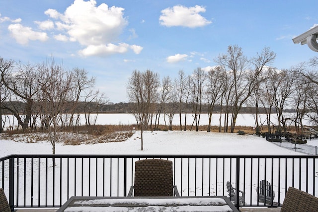 snow covered deck featuring a water view