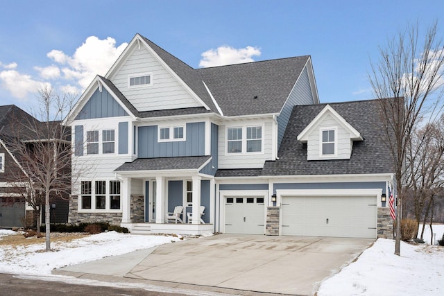 view of front of house with stone siding, board and batten siding, a shingled roof, and driveway