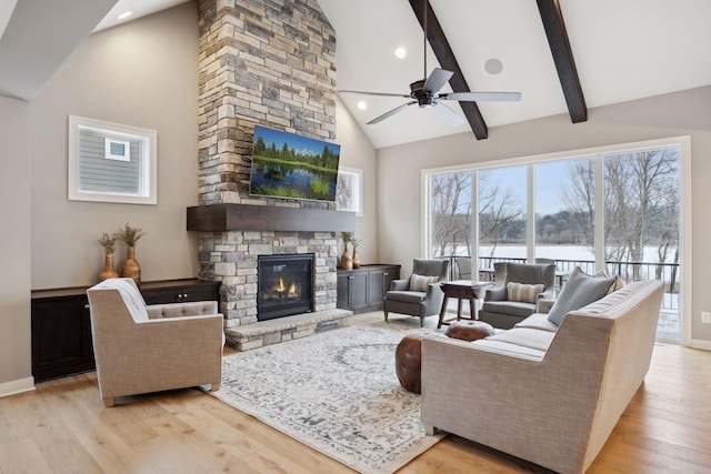 living room with beam ceiling, a fireplace, light wood-style floors, and high vaulted ceiling