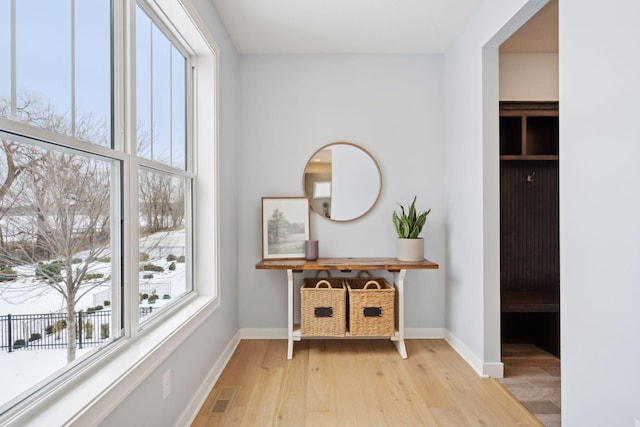 interior space featuring baseboards, visible vents, and light wood finished floors