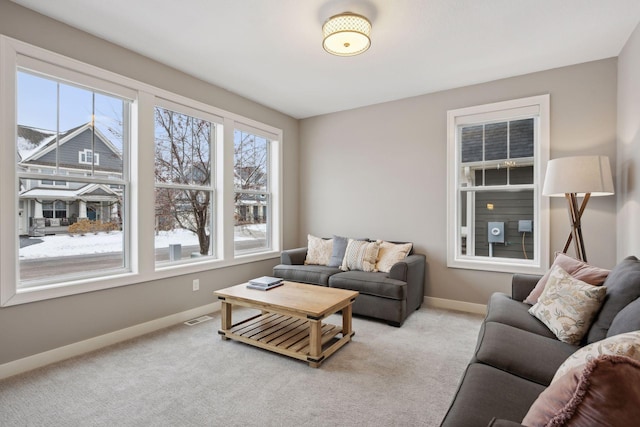 living area featuring baseboards, visible vents, and carpet floors