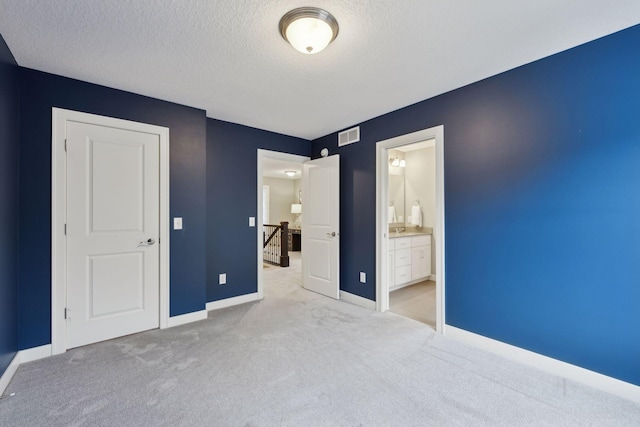 unfurnished bedroom with light carpet, visible vents, a textured ceiling, and baseboards