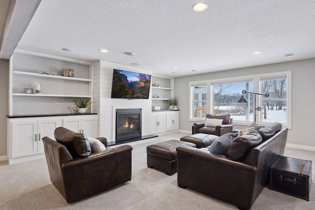 living area featuring a large fireplace, light carpet, a textured ceiling, and baseboards