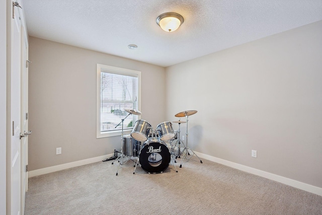 interior space with baseboards, a textured ceiling, and carpet flooring