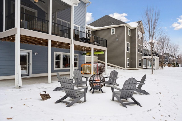 snow covered house with a residential view and an outdoor fire pit