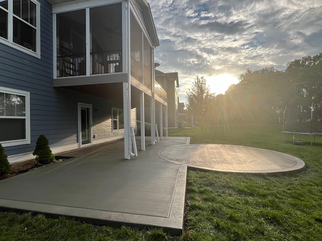 view of yard with a trampoline, a patio area, and a sunroom