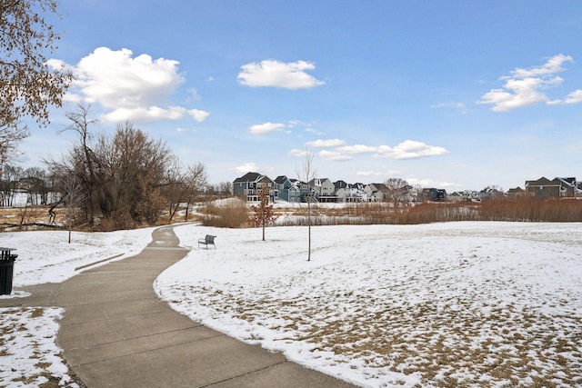 yard layered in snow featuring a residential view