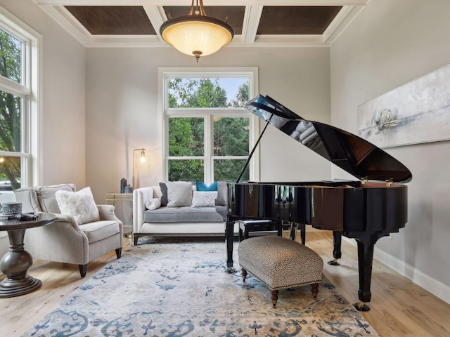 living area with plenty of natural light, coffered ceiling, baseboards, and wood finished floors