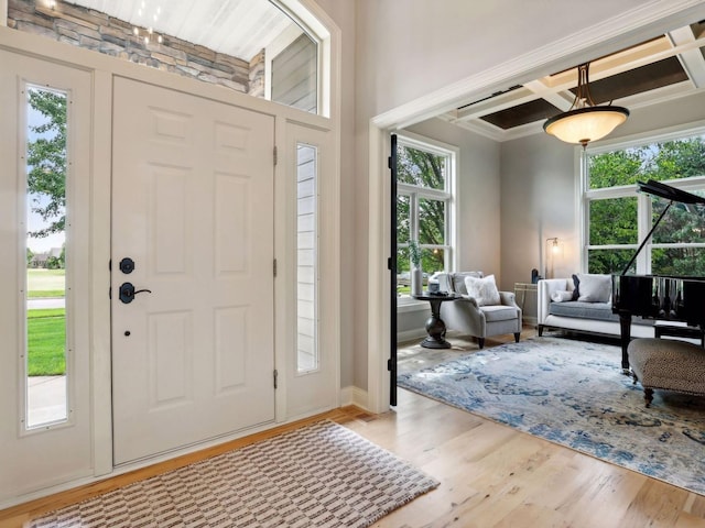 foyer entrance with a wealth of natural light, beam ceiling, coffered ceiling, and wood finished floors