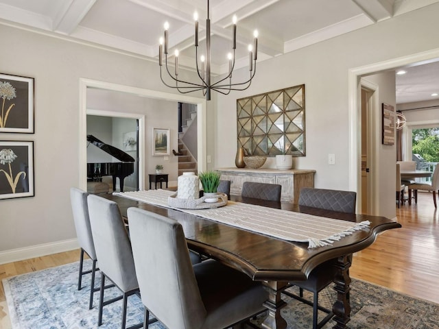 dining room with beam ceiling, stairway, baseboards, and wood finished floors