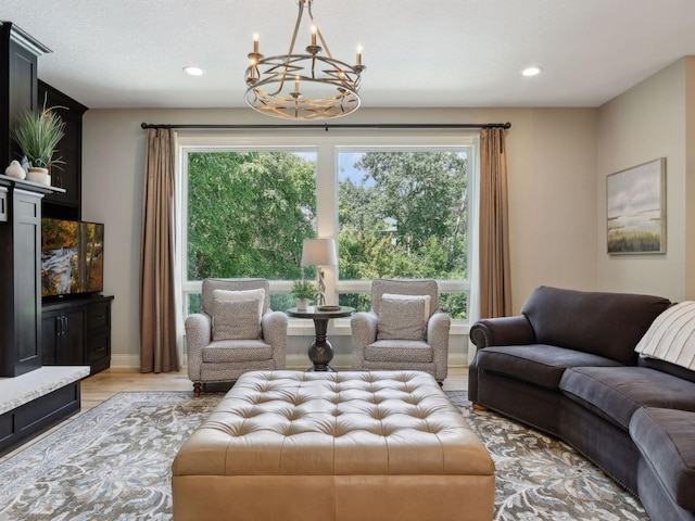 living area with recessed lighting, light wood-type flooring, baseboards, and a notable chandelier