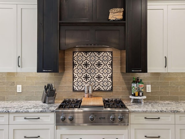 kitchen featuring light stone counters, decorative backsplash, white cabinets, and stainless steel gas stovetop