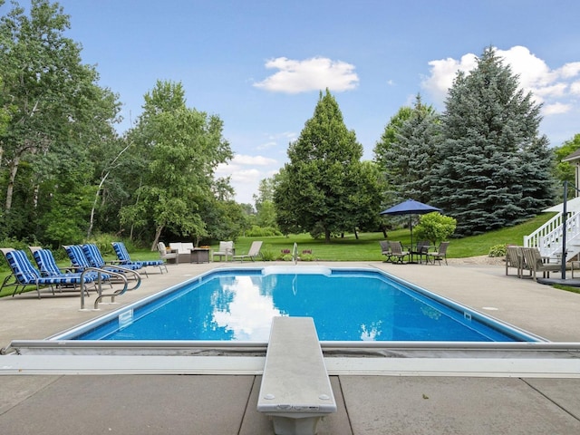 outdoor pool featuring a yard and a patio area