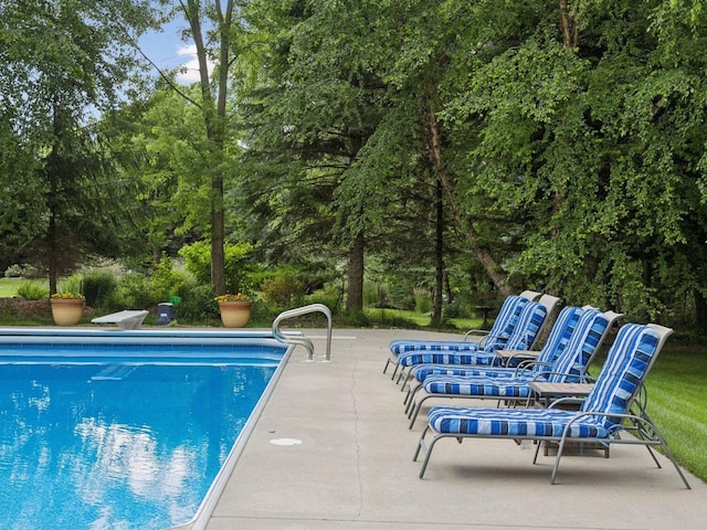 pool with a patio and a diving board