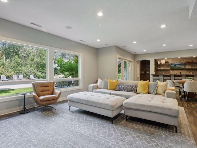 living area featuring recessed lighting, visible vents, baseboards, and wood finished floors