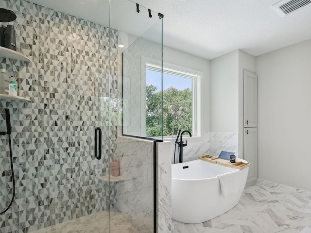 bathroom with visible vents, a soaking tub, a stall shower, tile walls, and marble finish floor