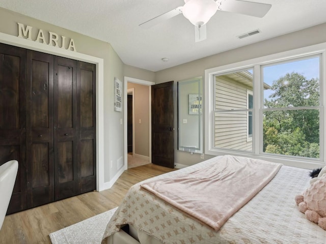 bedroom featuring a ceiling fan, baseboards, visible vents, a closet, and light wood-type flooring