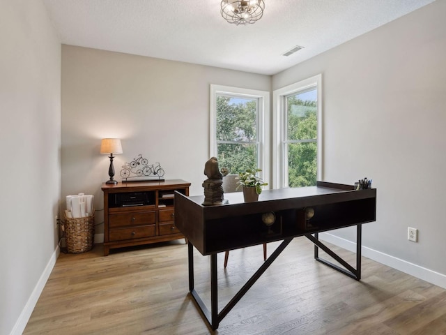 office area featuring visible vents, baseboards, and light wood finished floors