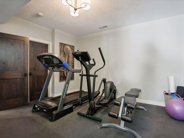 workout room with baseboards, visible vents, and a textured ceiling